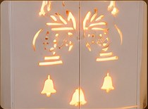 Cut-out pattern of bells and lamps lit from behind